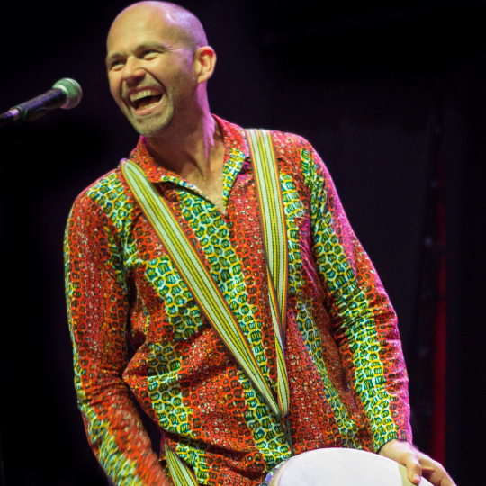 A drummer playing a djembe in the NZ drum camp