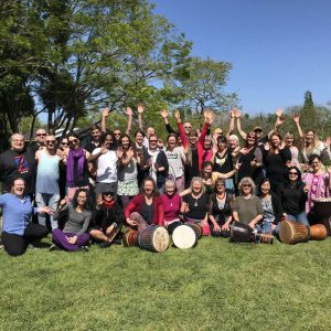 A group of people in a drumming retreat in new zealand with djembes